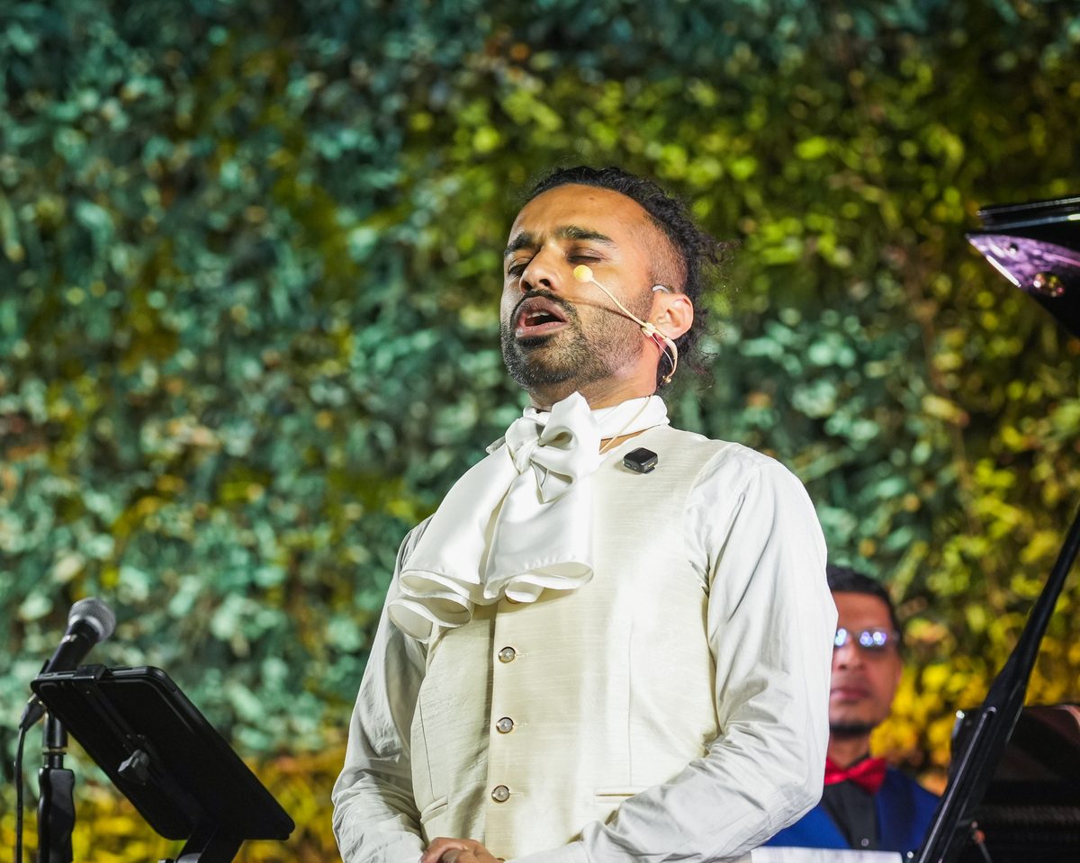 Oscar Castellino singing with eyes closed at Concerto de Natal
